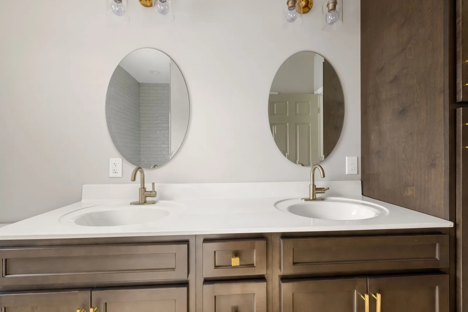 Modern bathroom vanity featuring dual sinks with oval mirrors and stylish fixtures. Perfect for home decor inspiration.